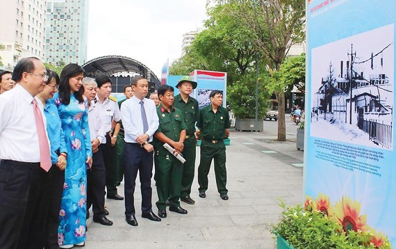 Deputy Secretary of the Party Committee of Ho Chi Minh City Tat Thanh Cang (L) attends the exhibition in Nguyen Hue walking street. (Photo: Sggp)