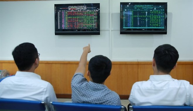 Investors follow stock movements at FPT Securities Company (FPTS) in Hanoi (Photo: VNA)