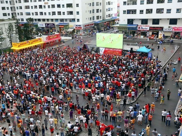 Fans gather outdoor to watch a football match (Photo: VNA)