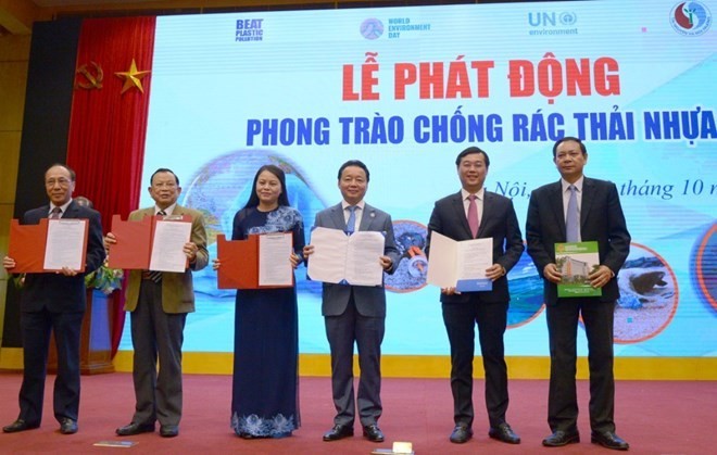 Officials show commitments at the launch of the national campaign to combat plastic pollution on October 12 (Photo: VNA)