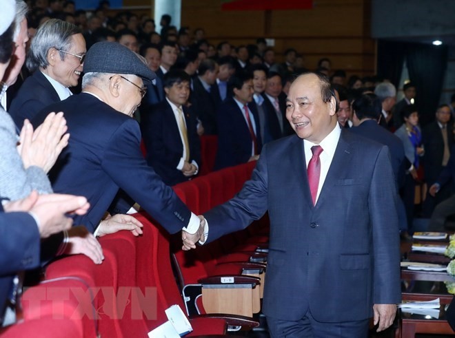Prime Minister Nguyen Xuan Phuc (R) greets participants in the meeting of PetroVietnam in Hanoi on January 11 (Photo: VNA)