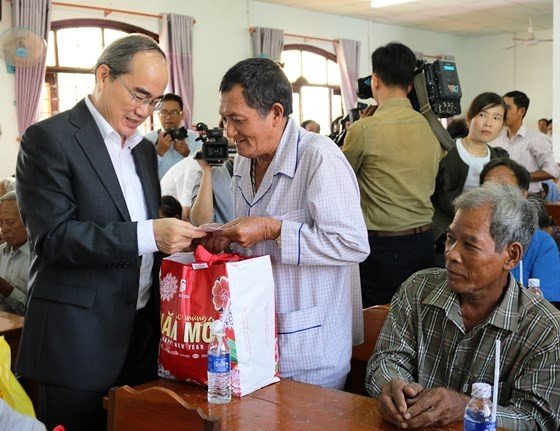 Secretary of HCMC Party Committee Nguyen Thien Nhan presents Tet gifts to local people in Chau Thanh district, Tra Vinh province. (Photo: Sggp)