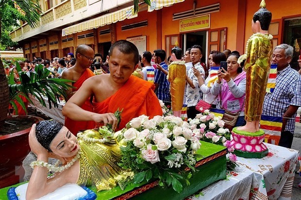 A Khmer monk bathes the Buddha statue on the traditional Chol Chnam Thmay festival (Photo: VNA)