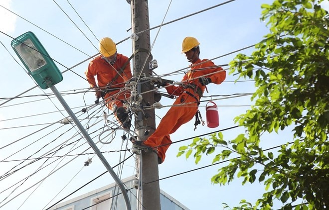 Workers repair electrical facilities (Photo: VNA)