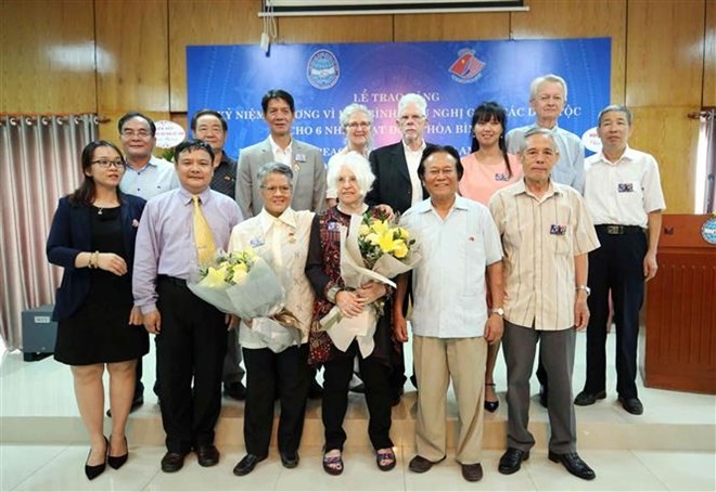 The US peace activists pose for a group photo with the Vietnamese delegates (Photo: VNA)