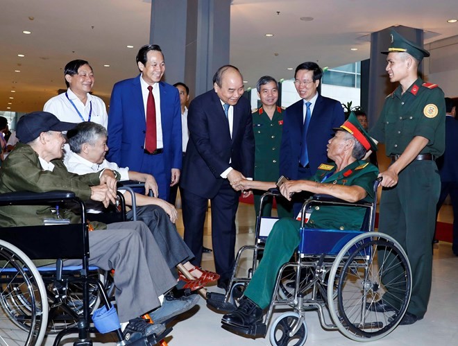 Prime Minister Nguyen Xuan Phuc (centre) meets with seriously injured war veterans at the gathering in Hanoi on July 25 (Photo: VNA)