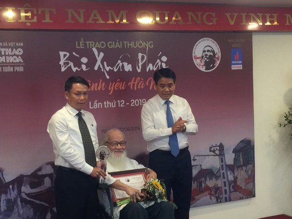 Assoc. Prof. Dr. Nguyen Thua receives the Grand Prize at the 12th Bui Xuan Phai Award-Love for Hanoi. (Photo: Sggp)