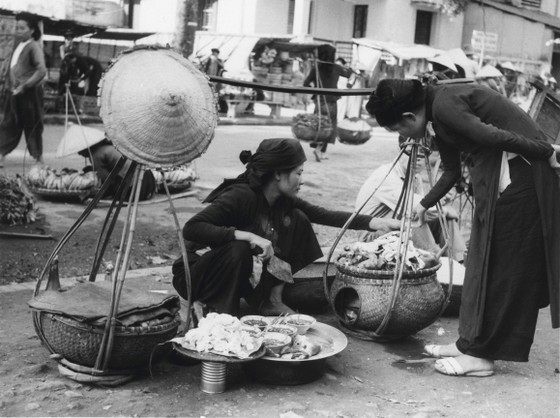 A vendor fills the baskets with goods.