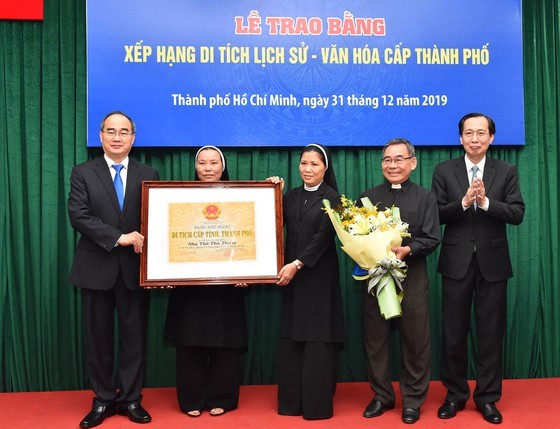 Secretary of HCMC Party Committee Nguyen Thien Nhan presents a certificate recognizing Thu Thiem Church as a historic and cultural site at the municipal level. (Photo: Sggp)