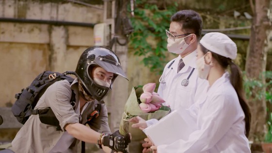 Globetrotter Tran Dang Dang Khoa offers flowers to frontline health workers.