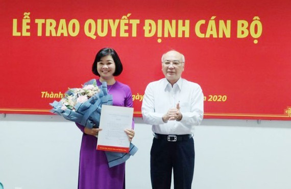 Head of the Propaganda Department of the City Party Committee, Phan Nguyen Nhu Khue hands over the appointment decision to Ms. Ly Viet Trung (L). (Photo: SGGP)