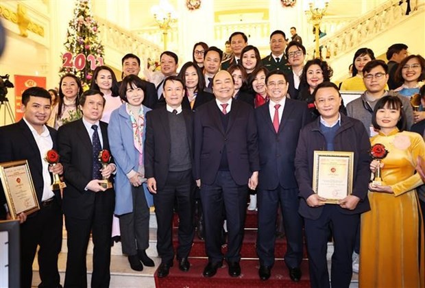 Prime Minister Nguyen Xuan Phuc (C) and Vietnam News Agency leaders pose for a photo with VNA journalists who win prizes of  fifth National Press Awards on Party building (Photo: VNA)