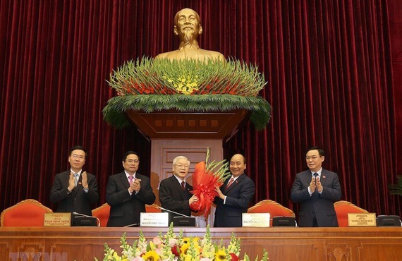 Prime Minister Nguyen Xuan Phuc offers flowers to General Secretary of the Communist Party of Vietnam Nguyen Phu Trong (Photo: VNA)