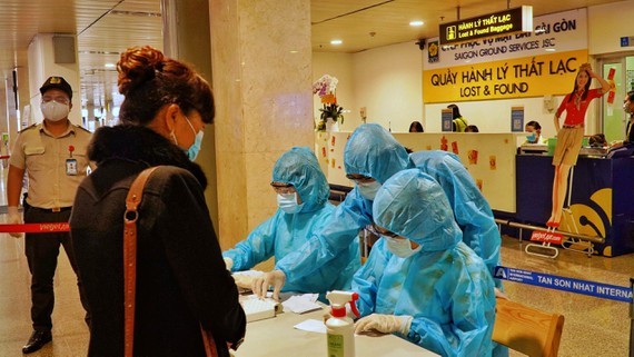 HCMC's authorities conduct random Covid-19 tests on passengers arriving at Tan Son Nhat International Airport. (Photo: SGGP)