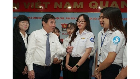 Chairman of the People's Committee of HCMC, Nguyen Thanh Phong (2nd, L) talks to schoolgirls at a meeting between the city's leaders and outstanding students in 2019. (Photo: SGGP)