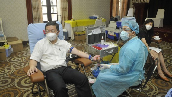 Vice Chairman of the HCMC People’s Committee Duong Anh Duc (L) participates in a voluntary blood donation on August 4. (Photo: SGGP)