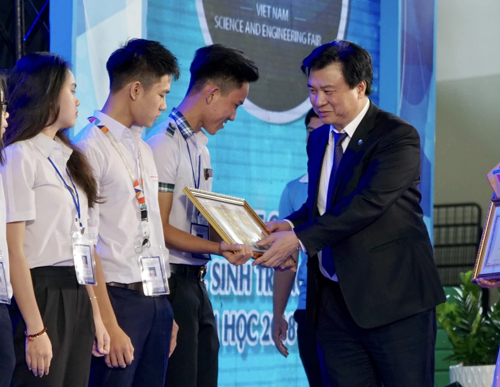 Thứ trưởng Bộ GD-ĐT Nguyễn Hữu Độ trao giải nhất cho các thí sinh. Ảnh: HOÀNG HÙNG