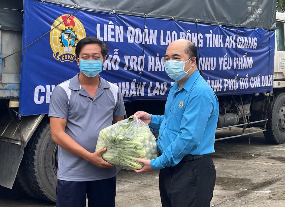 Phó chủ tịch LĐLĐ TPHCM Hồ Xuân Lâm trao quà từ tỉnh An Giang đến các công đoàn cơ sở để tặng công nhân lao động