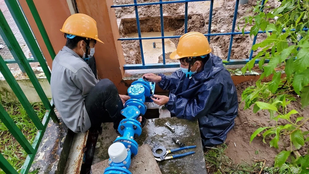 Nhân viên ngành nước lắp đường ống, đầu hồ nước