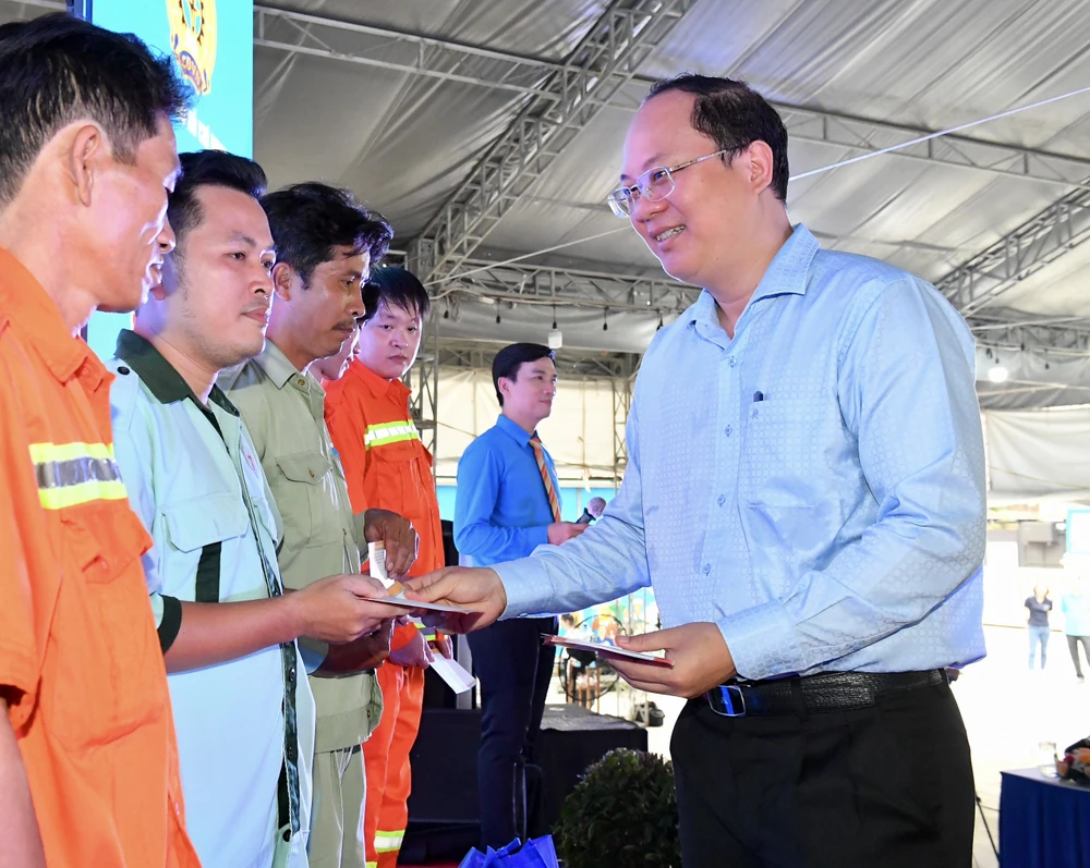 Phó Bí thư Thành ủy TPHCM Nguyễn Hồ Hải tặng quà công nhân khó khăn. Ảnh: VIỆT DŨNG