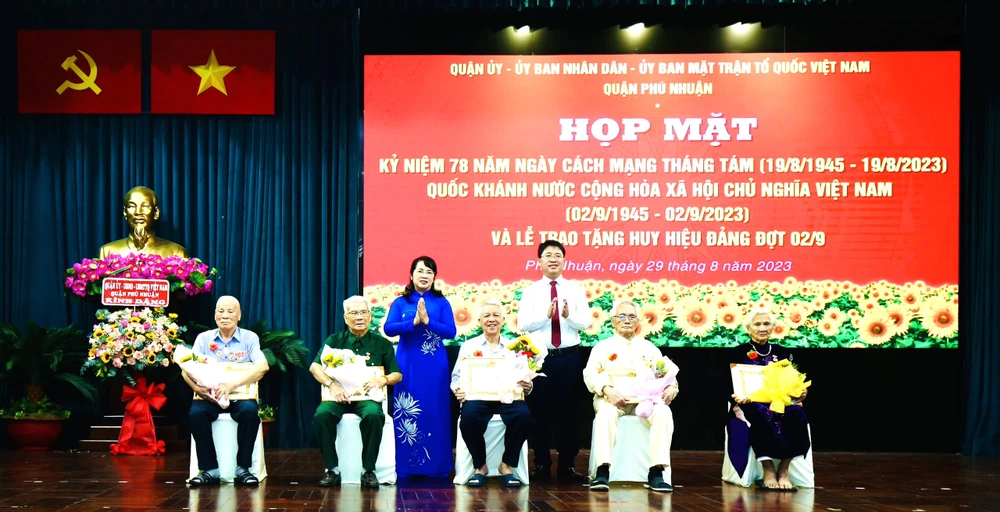 Chủ tịch Ủy ban MTTQ Việt Nam TPHCM Trần Kim Yến chúc mừng các đảng viên cao tuổi Đảng tại quận Phú Nhuận nhận Huy Đảng đợt 2-9. Ảnh: BÙI HẢI