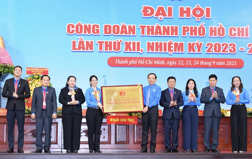 Bí thư Thành ủy TPHCM Nguyễn Văn Nên trao tặng Bảng đồng với dòng chữ Công đoàn TPHCM Đổi mới – Dân chủ – Đoàn kết – Phát triển đến đại hội. Ảnh: VIỆT DŨNG.