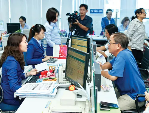 Khách hàng giao dịch tại Eximbank. Ảnh: LONG THANH