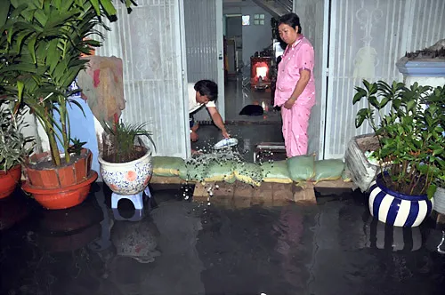 Người dân dùng bao cát đắp đê, be bờ không cho nước tràn vào nhà. Người dân dùng bao cát đắp đê, be bờ không cho nước tràn vào nhà.