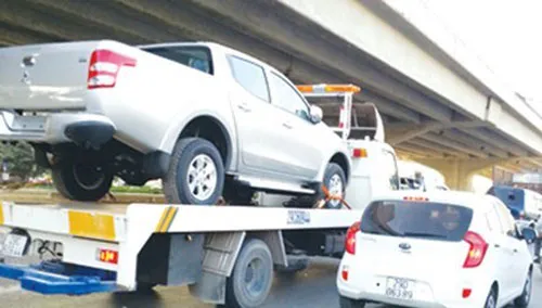 Một xe cứu hộ trá hình chở xe Mitsubishi mới tinh diễu phố Hà Nội giờ cao điểm. Ảnh: Mỹ Duyên