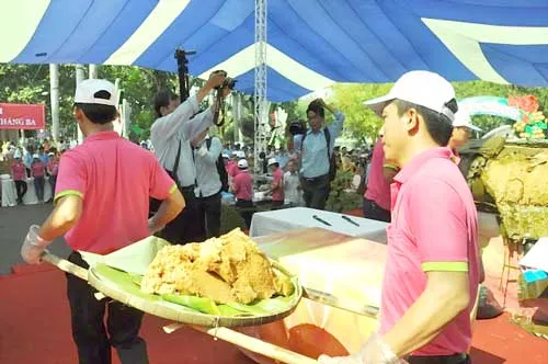 Bánh chưng khủng được nhân viên công viên văn hóa Đầm Sen phân nhỏ và chia cho người dân. Bánh chưng khủng được nhân viên công viên văn hóa Đầm Sen phân nhỏ và chia cho người dân.