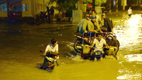 Một chiếc xe chết máy cầu cứu xe ba gác chở thuê qua khỏi điểm ngập nước.