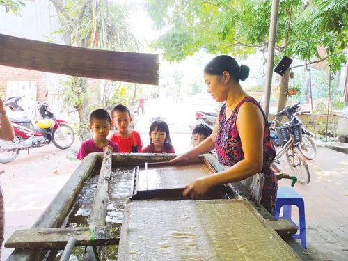 Bà Ngô Thị Thu đang seo giấy. Bà Ngô Thị Thu đang seo giấy.