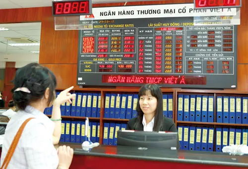 Khách hàng tham khảo biểu lãi suất tại VietABank. Ảnh: LONG THANH