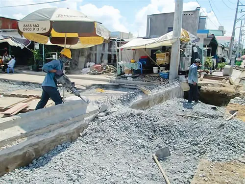 Công nhân Riviera Point phá taluy, đào đường thi công cống thoát nước.Ảnh: MINH TUẤN