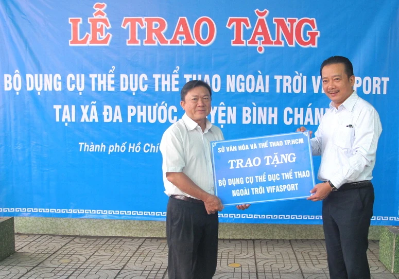 Ông Võ Trọng Nam (phải, Phó Giám đốc Sở VH-TT TPHCM) trao bảng tặng tượng trưng cho ông Phạm Thanh Hùng, Phó chủ tịch UBND xã Đa Phước.