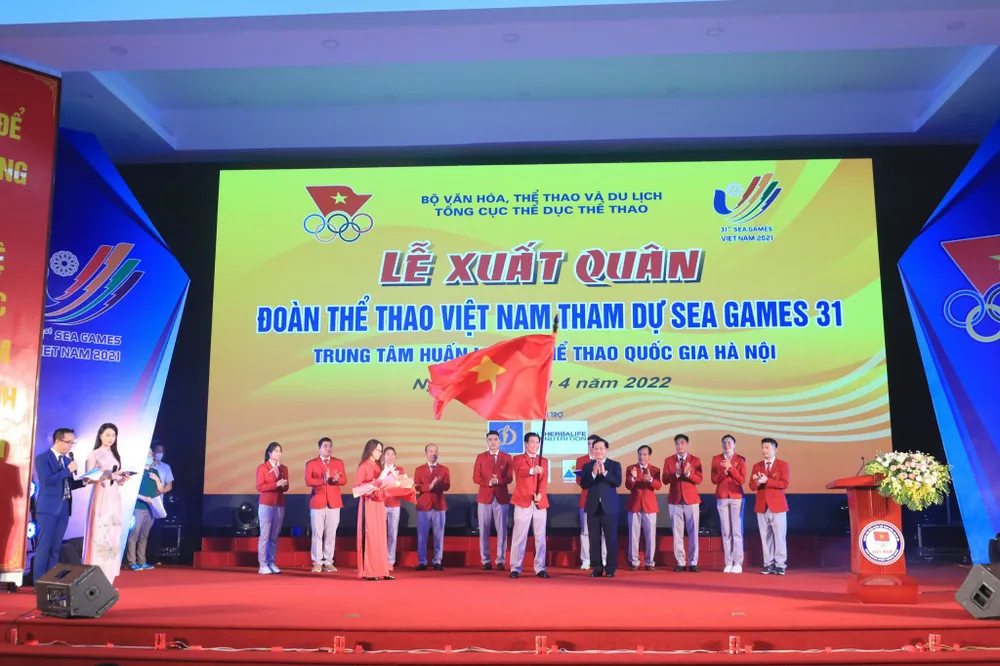 Phó Thủ tướng thường trực Chính phủ Phạm Bình Minh trao lá quốc kỳ cho Trưởng đoàn TTVN tại Lễ Xuất quân tối 28-4. Ảnh: MINH CHIẾN