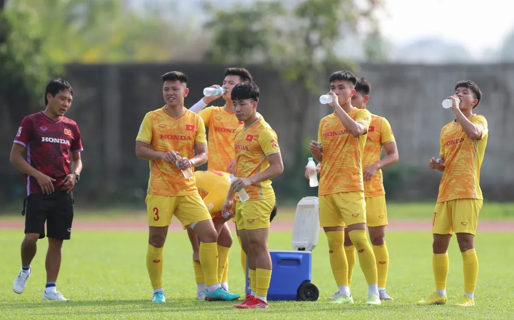 Các cầu thủ tiếp nước giữa buổi tập. Thời tiết nắng nóng tại Phnom Penh hiện nay cũng là trở ngại với các đội. Ảnh: QUỲNH MAI