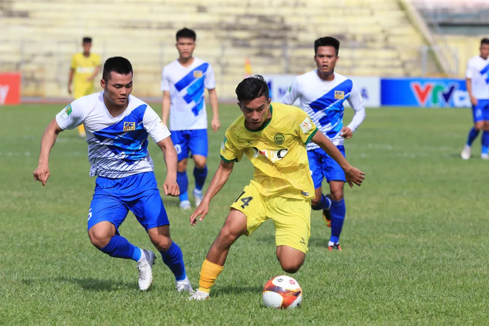 Hòa Bình (áo vàng) thắng Huế ở phút bù giờ. Ảnh: MINH HOÀNG