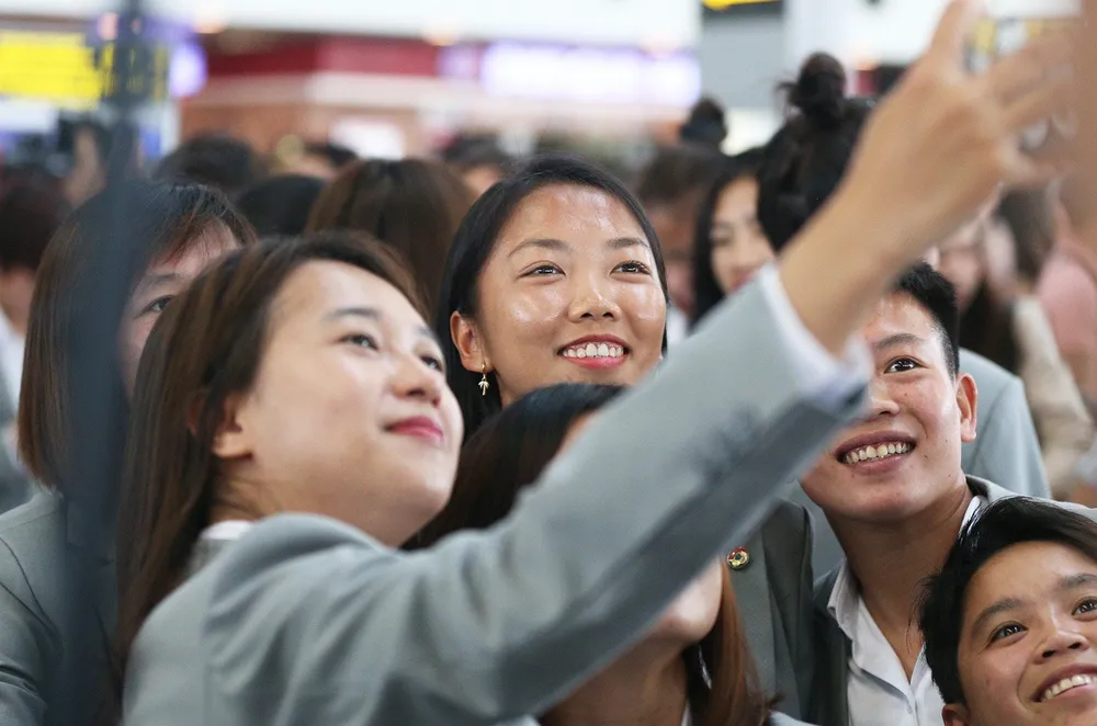 Các nữ tuyển thủ chụp hình kỷ niệm cùng người hâm mộ tại sân bay Nội Bài
