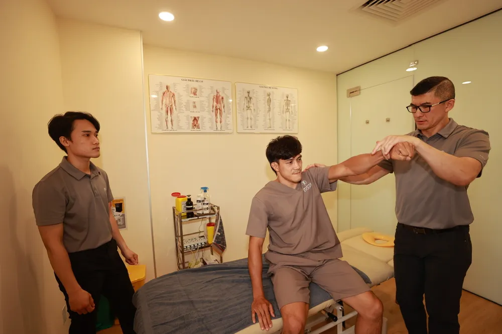 Chuyên gia Ben Duong trị liệu cánh tay cho võ sĩ Nguyễn Trần Duy Nhất. Ảnh: DŨNG PHƯƠNG Chuyen gia va Nguyen Tran Duy Nhat 8.jpg