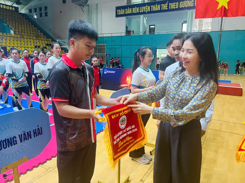 Đại diện Ban tổ chức trao cờ lưu niệm cho đại diện các đơn vị tham dự. Ảnh: TRÚC GIANG gen-h-Aerobic 1.jpg