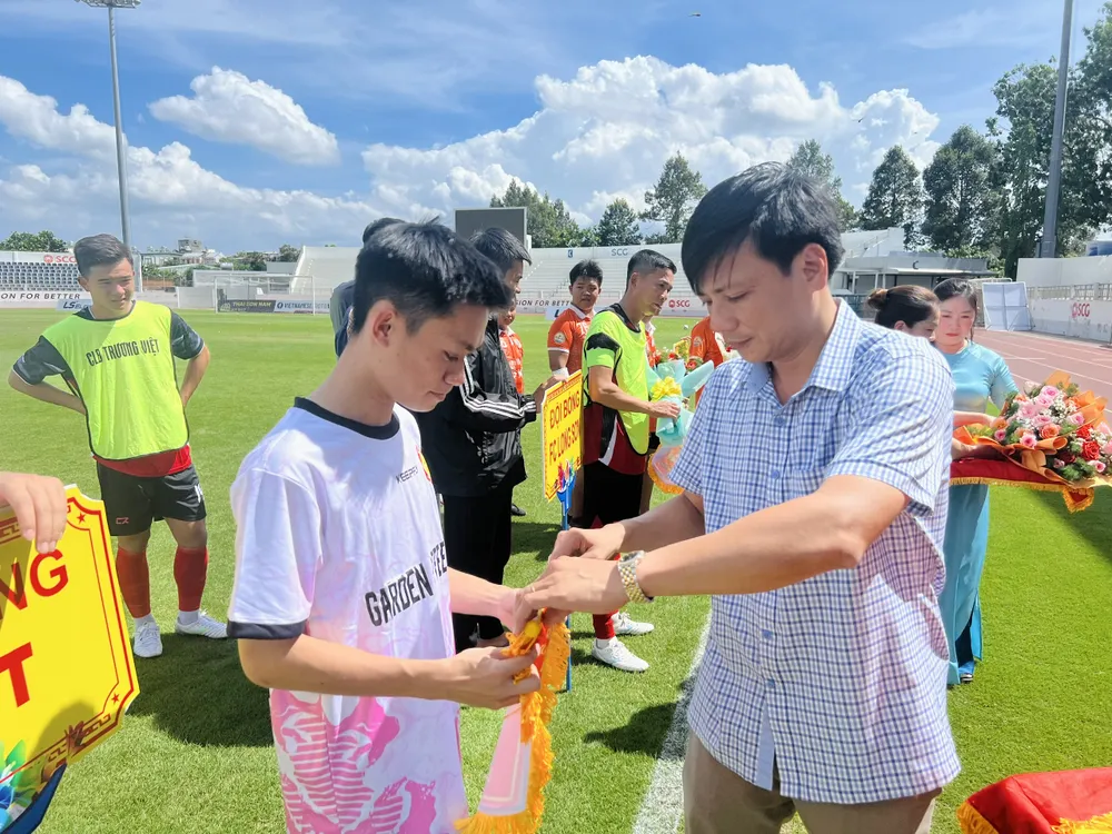 Ban tổ chức trao cờ lưu niệm cho các đội tham dự giải. Ảnh: TRÚC GIANG