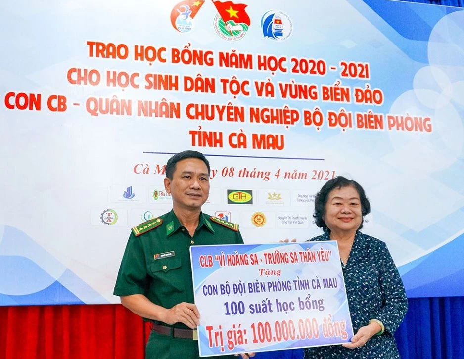 Đại tá Nguyễn Quang Hà, Phó Chính ủy Bộ Chỉ huy Bộ đội Biên phòng tỉnh Cà Mau nhận bảng tượng trưng 100 suất học bổng trị giá 100 triệu đồng do bà Trương Mỹ Hoa trao tặng. Ảnh: BĂNG THANH