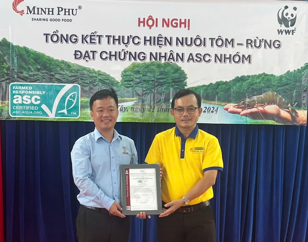 Ông Trần Phương Đại (bìa trái), Giám đốc kinh doanh tổ chức chứng nhận Bureau Veritas trao chứng nhận ASC Group mô hình tôm - rừng tại xã Tân Ân Tây cho đại diện Công ty TNHH Xã hội tôm chứng nhận Minh Phú Tom rung.jpg