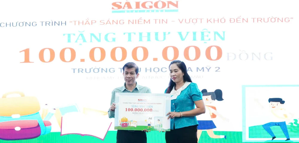 Nhà báo Nguyễn Khắc Văn, Phó Tổng Biên tập Phụ trách Báo Sài Gòn Giải Phóng, trao bảng tượng trưng tặng trang thiết bị thư viện cho đại diện Trường Tiểu học xã Hòa Mỹ (huyện Cái Nước, tỉnh Cà Mau)