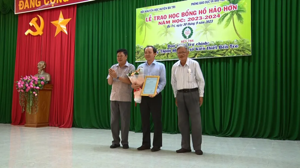 Chủ tịch UBND huyện Ba Tri Dương Minh Tùng (trái) tặng kỷ niệm chương và thư cảm ơn cho lãnh đạo công ty