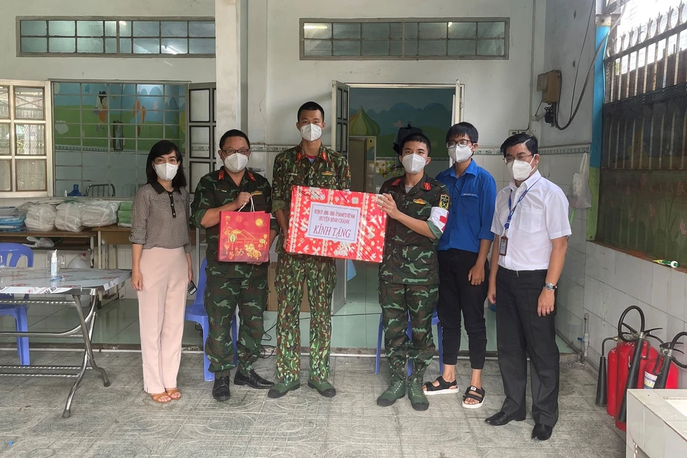  Phó Bí thư Thường trực Đảng ủy Tổng Công ty Điện lực TPHCM Bùi Hải Thành (bìa phải) thăm và tặng quà các y bác sĩ, nhân viên Trạm y tế lưu động số 12 tại xã Đa Phước, huyện Bình Chánh