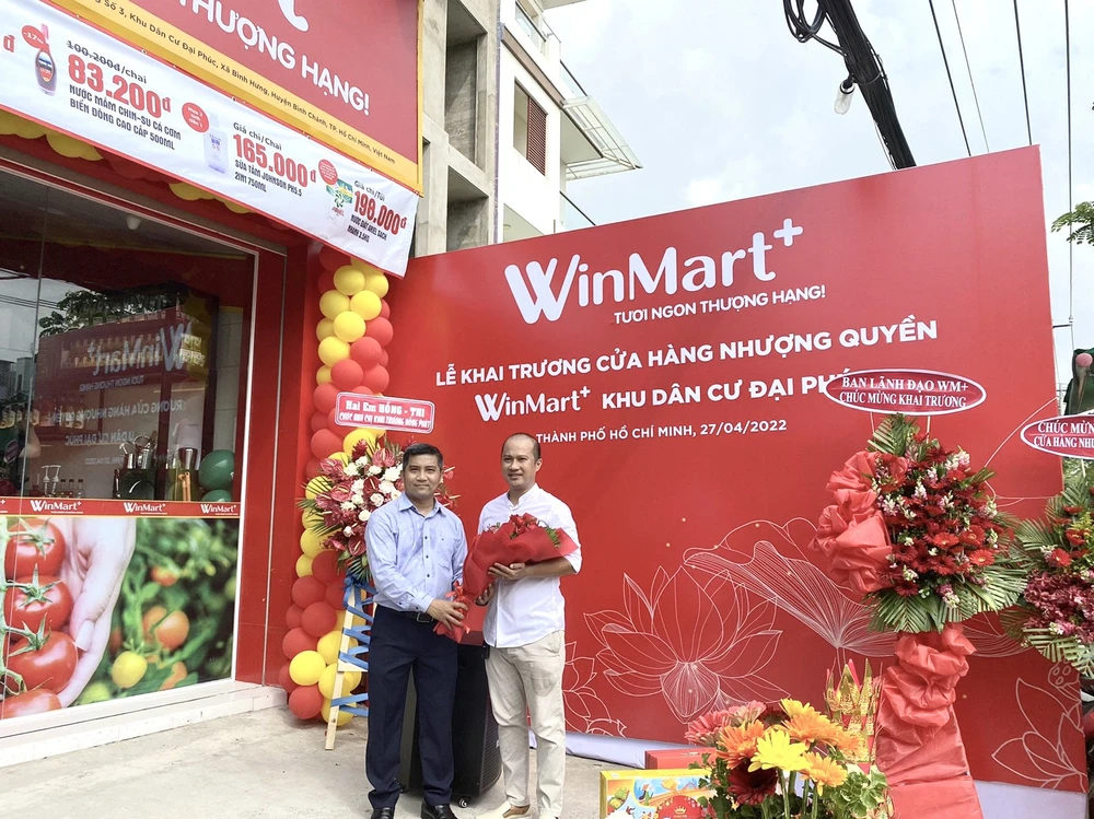 Đại diện WinCommerce chúc mừng anh Nguyễn Hoài Nam - chủ cửa hàng WinMart+ nhượng quyền đầu tiên tại TPHCM