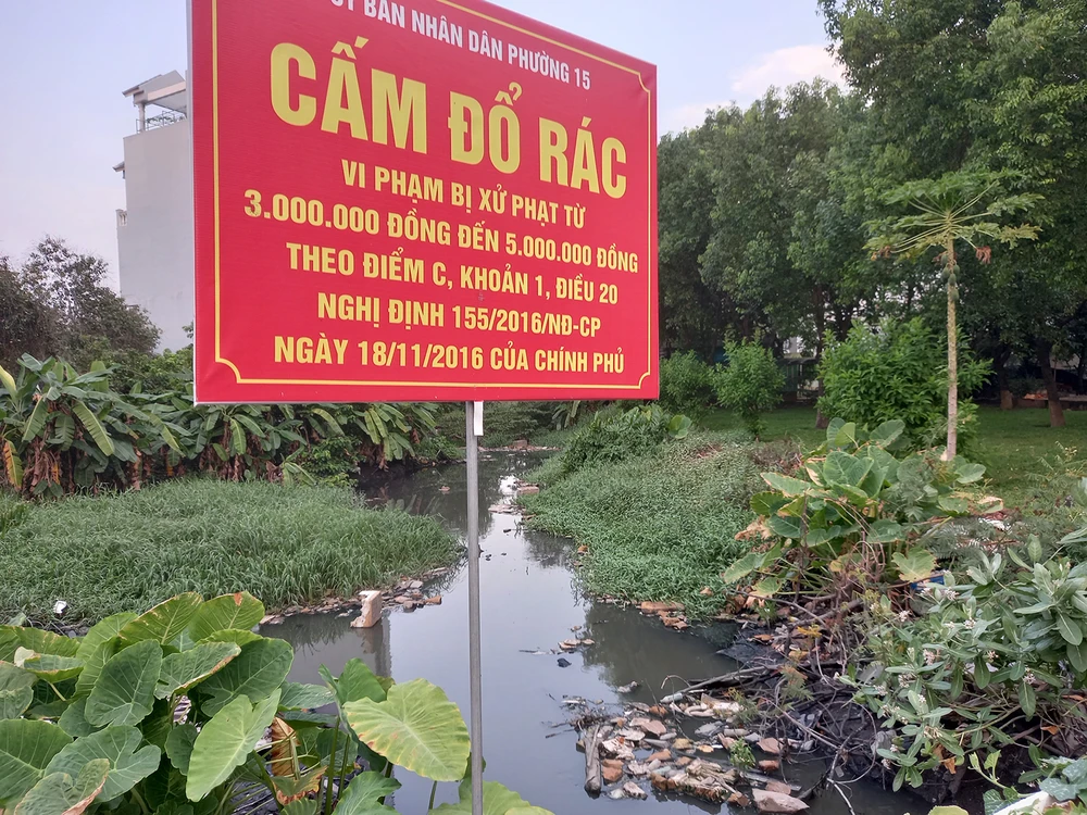 Một con rạch ở phường 15 (quận Gò Vấp) bị người dân quăng rác dày đặc, gây tắc nghẽn dòng chảy và bốc mùi hôi thối, dù có biển cấm đổ rác của UBND phường. Ảnh: Đức Trung