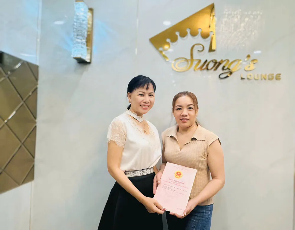 Bà Võ Thu Sương (bên trái) tặng sổ đỏ bà Trần Thị Bảy Anh 2.jpg